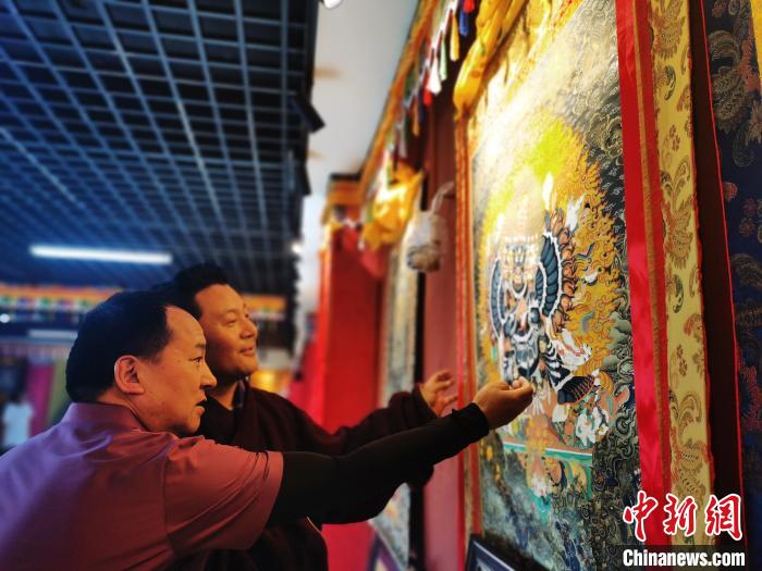 圖為(wei) 久美尖措展示唐卡作品。　張添福 攝