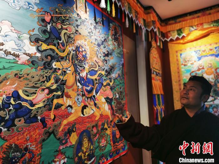 圖為(wei) 久美尖措展示唐卡作品。　張添福 攝