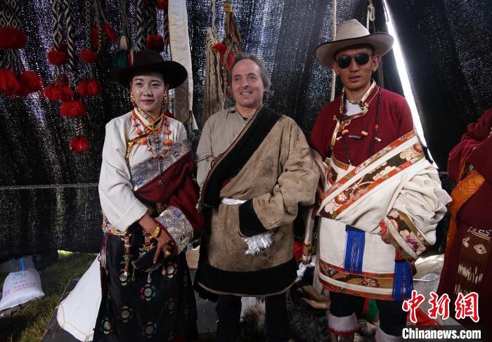圖為(wei) 一名外籍攝影師(中)身穿藏服和藏族民眾(zhong) 合影留念。　馬銘言 攝