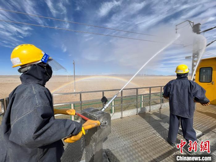 圖為(wei) 水炮手操作高壓水槍對絕緣子進行清洗。　高啟宏 攝