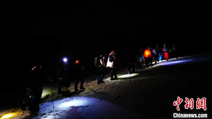 圖為(wei) 5日淩晨出發的登山者在攀登洛堆峰途中。　張偉(wei)  攝