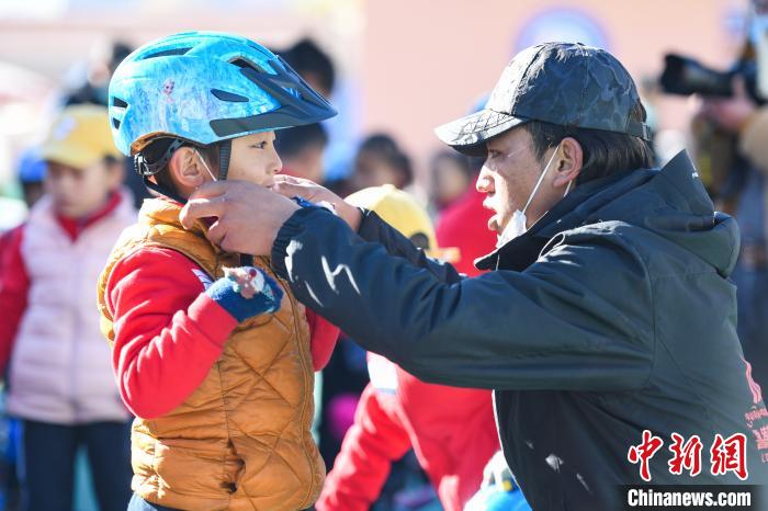 圖為(wei) 拉薩市實驗幼兒(er) 園孩子在教練的幫助下穿戴頭盔。　何蓬磊 攝