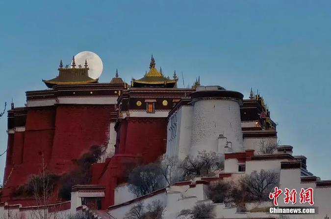 圖為(wei) 一輪明月從(cong) 布達拉宮上空緩緩升起。馬謙 攝