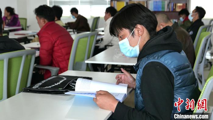 圖為(wei) 正在閱讀“傑鬆達孜”藏曆法教材的學員。　謝牧 攝