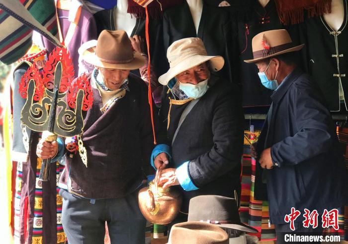 圖為(wei) 三位藏族老人在集市上聊天交談。　冉文娟 攝