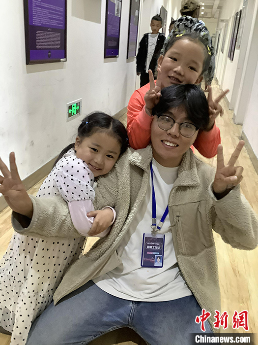 “Z世代”旦真旺加認為(wei) ，拉薩是一座開放與(yu) 包容的城市，記憶中的拉薩是彩色的。2021年，旦真旺加從(cong) 浙江大學漢語言文學專(zhuan) 業(ye) 畢業(ye) 後，他選擇回到拉薩，成為(wei) 一名漢語文實習(xi) 助教。圖為(wei) 8月4日，旦真旺加在課間陪學生玩耍。 <a target='_blank' href='https://www.chinanews.com/'><p  align=