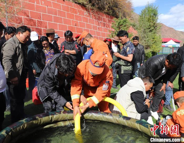 圖為(wei) 森林消防員為(wei) 護林員講解滅火裝備的使用方法。　昌都市森林消防支隊 供圖