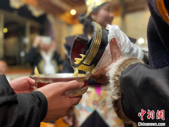 圖為(wei) 主人在碗中斟滿青稞酒。　冉文娟 攝