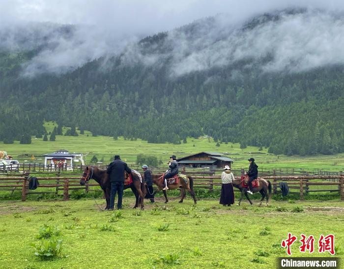 6月10日，遊客在魯朗小鎮高山牧場景區體(ti) 驗騎馬。　冉文娟 攝