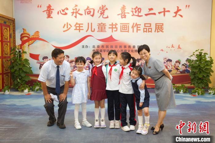 圖為(wei) 與(yu) 會(hui) 嘉賓與(yu) 入選畫作的“小作者”們(men) 在展覽上合影。　中國藏學研究中心供圖