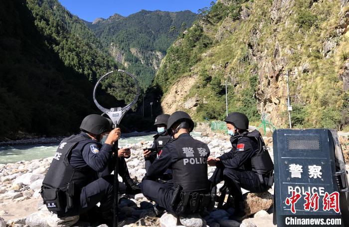 圖為(wei) 西藏吉隆出入境邊防檢查站移民管理警察在中尼邊境巡邏途中收看二十大開幕直播。　郭章統 攝