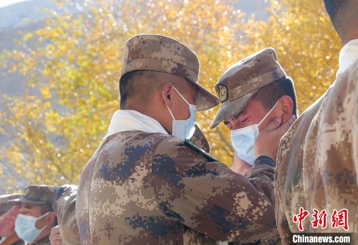 圖為(wei) 什布奇邊防連退伍老兵與(yu) 戰友相擁而泣，依依惜別。　徐昌成 攝
