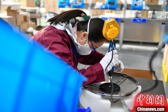 圖為(wei) 工人正在組裝炊具。　貢嘎來鬆 攝