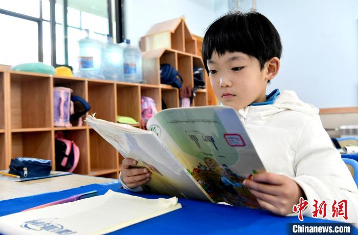 3月14日，西藏拉薩市第一小學一年級六班學生丁增樂(le) 吉在閱讀藏語課本。　李林 攝