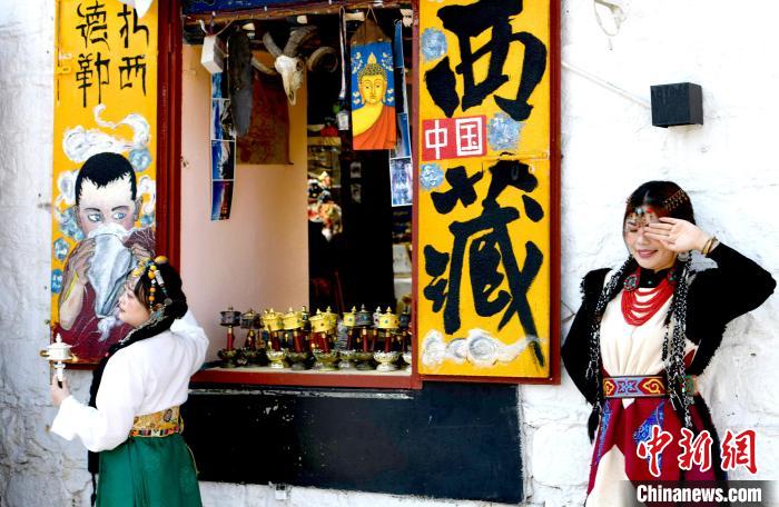 4月17日，遊客身著藏式元素服裝在拉薩八廓街拍照留念。　李林 攝
