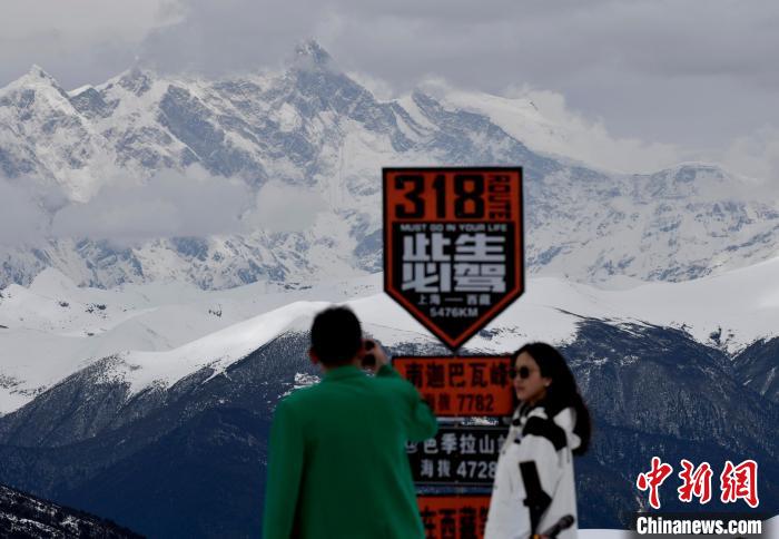 圖為(wei) 5月14日，西藏林芝色季拉山觀景台，遊客遠眺南迦巴瓦峰。　　李林 攝